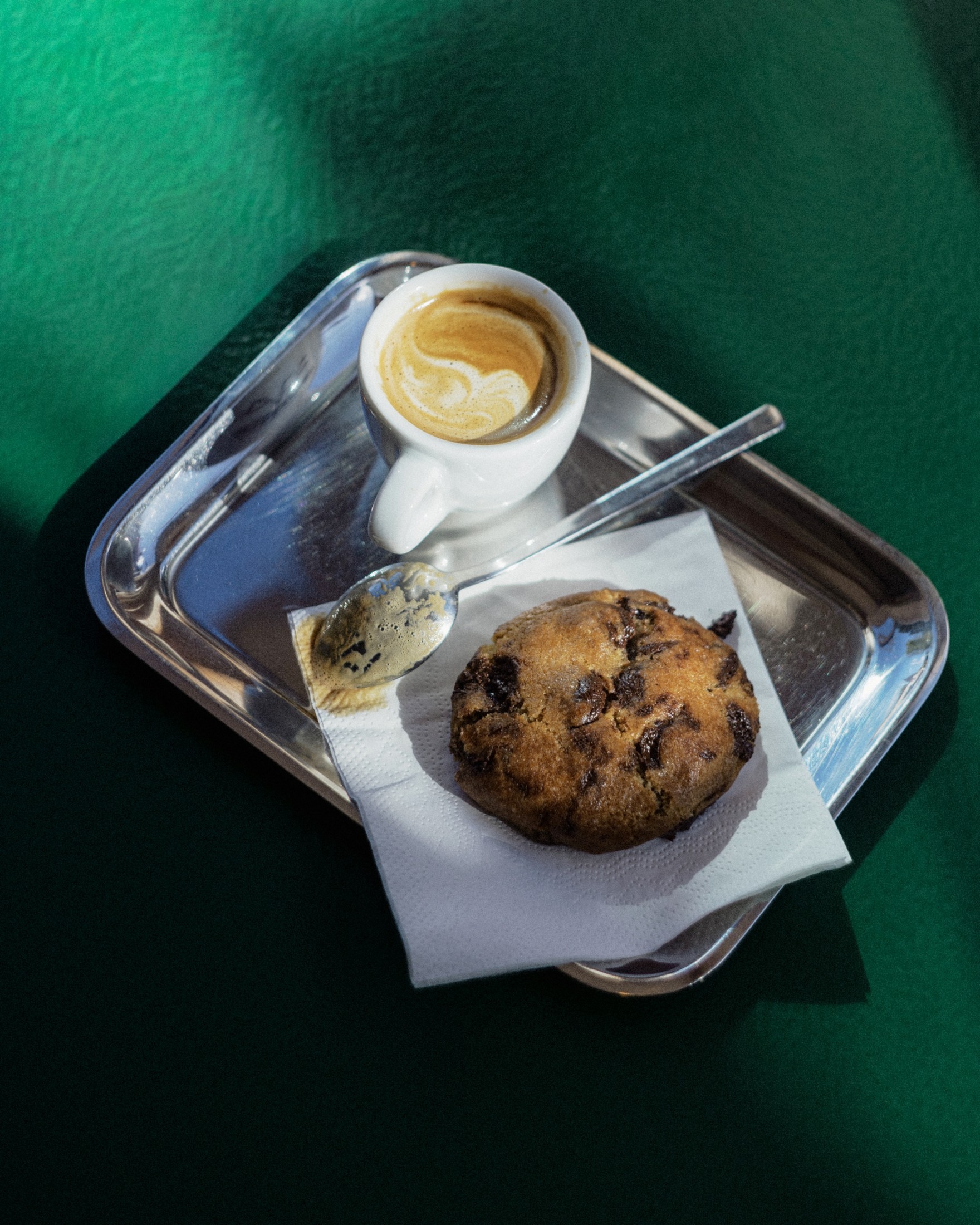 Overhead shot of an espresso and a cookie on a tray