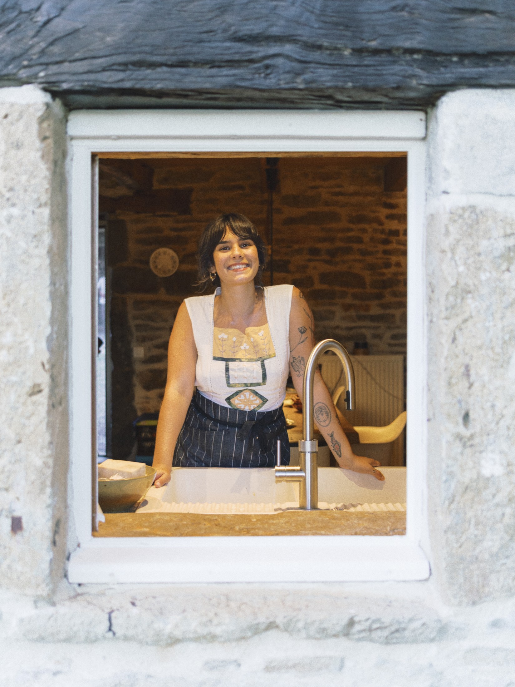 Portrait of a woman in a headscarf standing at a window