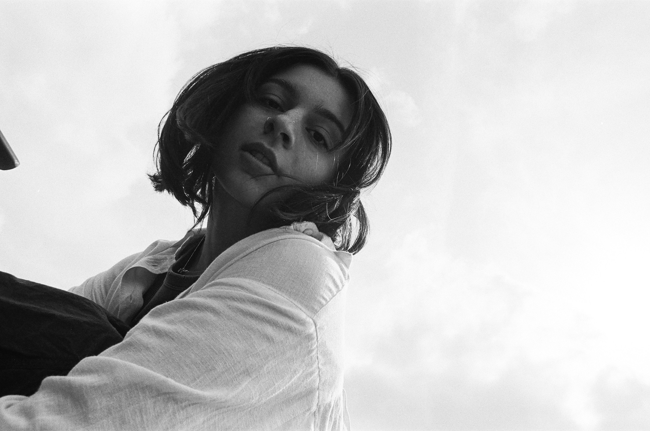 Black-and-white close-up portrait of a woman lying down with eyes closed
