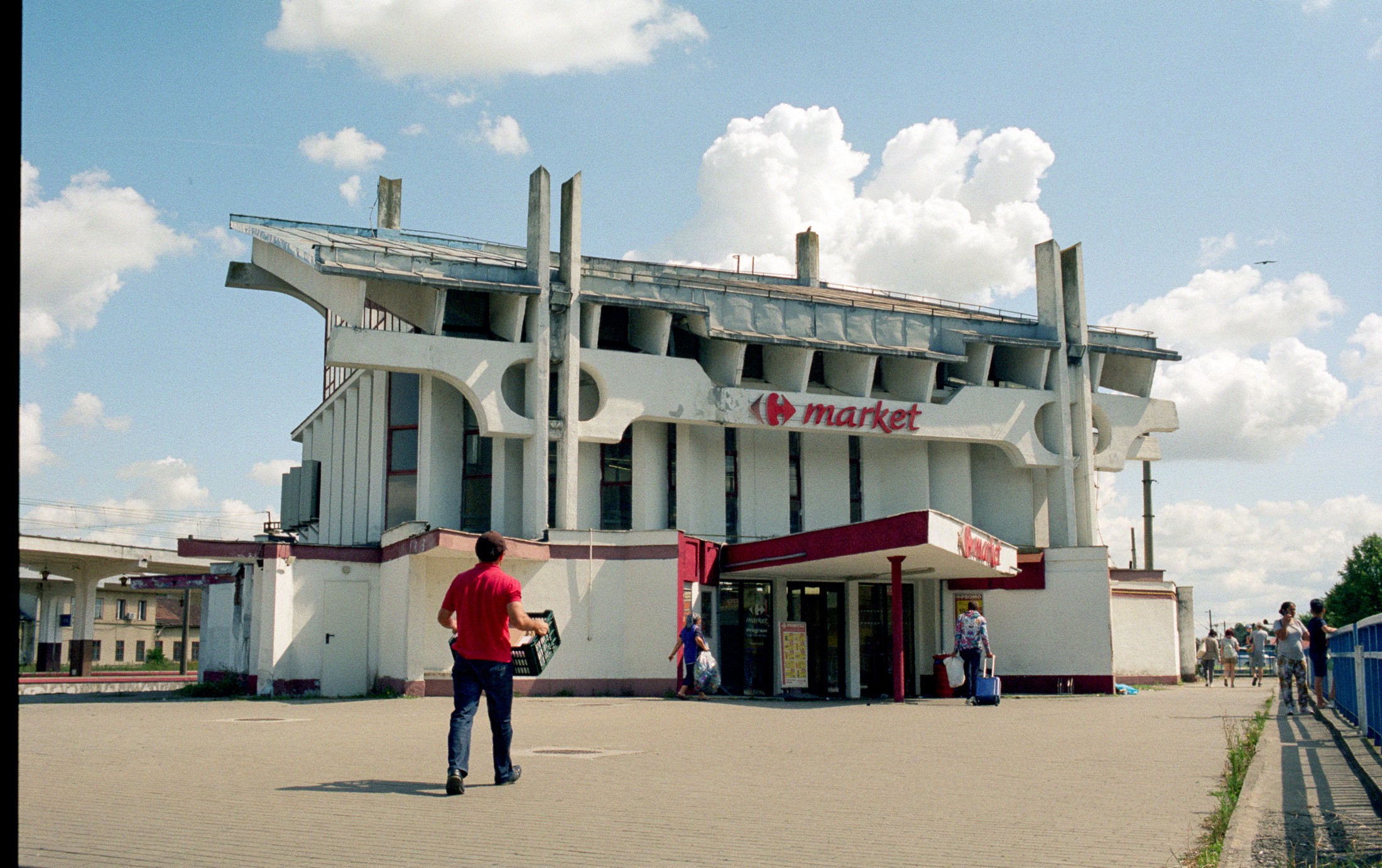 Street scene at a seaside market kiosk with people walking past