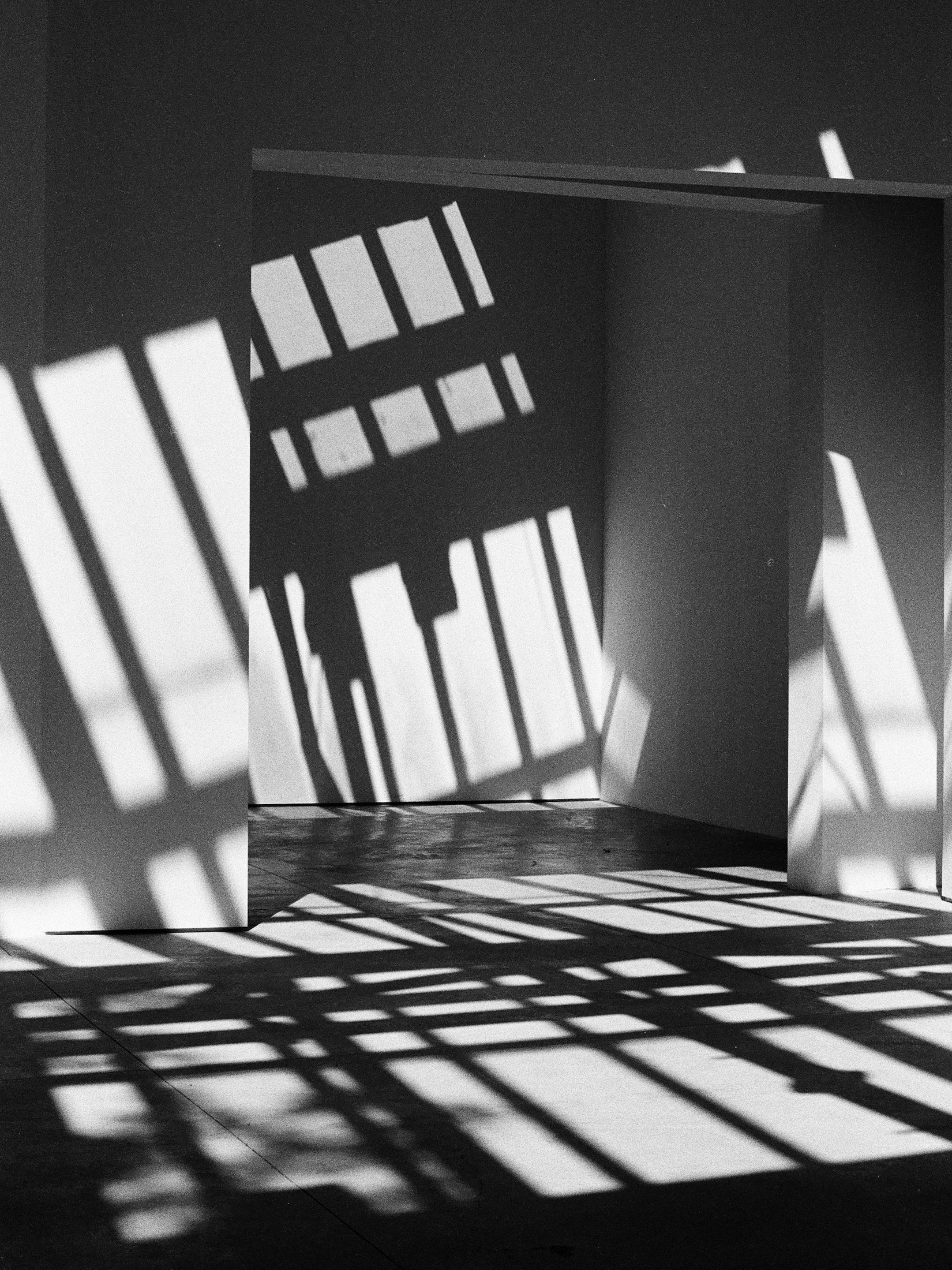 Black-and-white abstract shot of light and shadow through a geometric structure